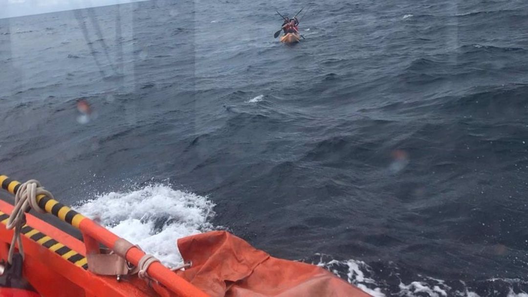 Una embarcación rescata a dos personas de un kayak. Una embarcación rescata a dos personas de un kayak.