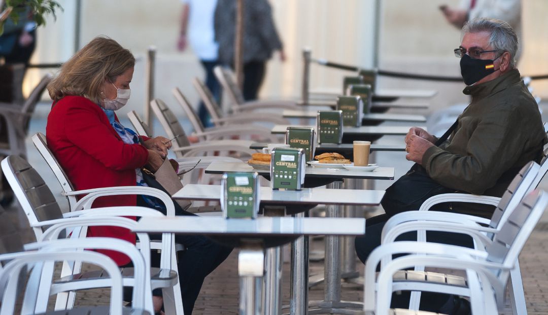 Dos personas con mascarilla en la terraza de un bar. Dos personas con mascarilla en la terraza de un bar.