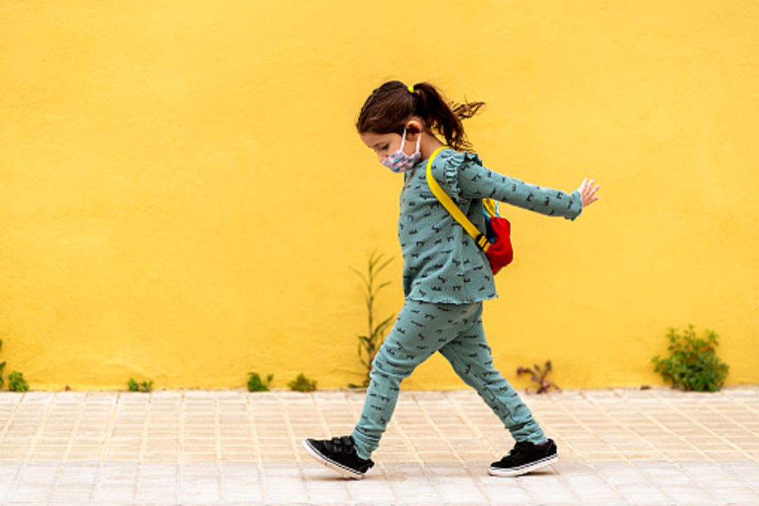 Niña con mascarilla caminando Niña con mascarilla caminando