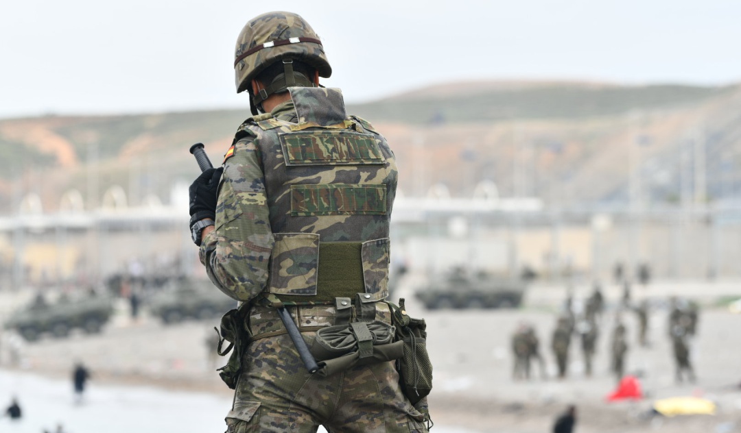 Un militar del ejército español vigila durante las devoluciones en caliente que están efectuando a los migrantes que han entrado en Ceuta procedente de Marruecos, a 18 de mayo de 2021, en Ceuta, (España). Al menos 2.700 personas han sido devueltas a Marruecos en las últimas horas tras asaltar la frontera de Ceuta con la complicidad de las autoridades marroquíes
Un militar del ejército español vigila durante las devoluciones en caliente que están efectuando a los migrantes que han entrado en Ceuta procedente de Marruecos, a 18 de mayo de 2021, en Ceuta, (España). Al menos 2.700 personas han sido devueltas a Marruecos en las últimas horas tras asaltar la frontera de Ceuta con la complicidad de las autoridades marroquíes