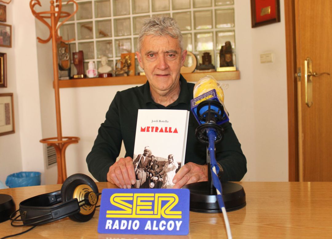 Jordi Botella, amb un exemplar de la seua novel·la 'Metralla' en l'estudi central de Radio Alcoy Jordi Botella, amb un exemplar de la seua novel·la 'Metralla' en l'estudi central de Radio Alcoy