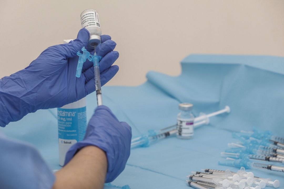 Una profesional sanitaria sostiene una jeringuilla junto a un vial con la vacuna Una profesional sanitaria sostiene una jeringuilla junto a un vial con la vacuna