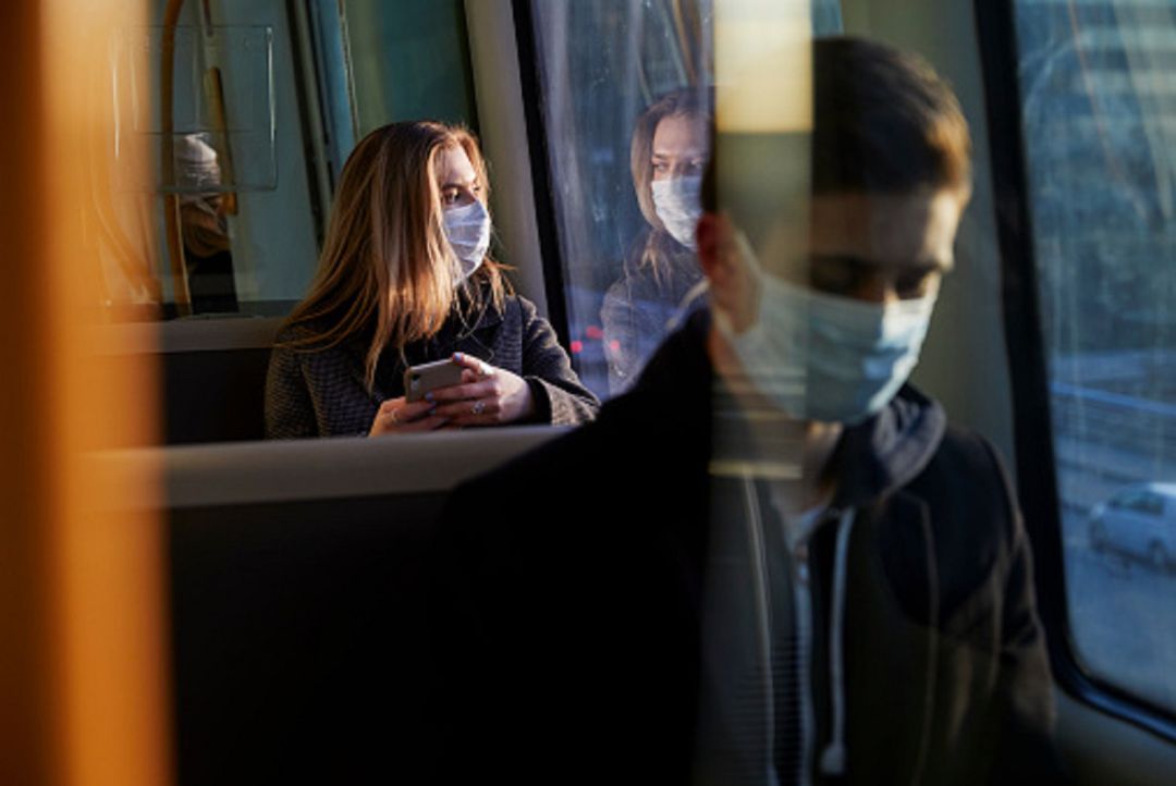 Jóvenes con mascarilla en transporte público Jóvenes con mascarilla en transporte público