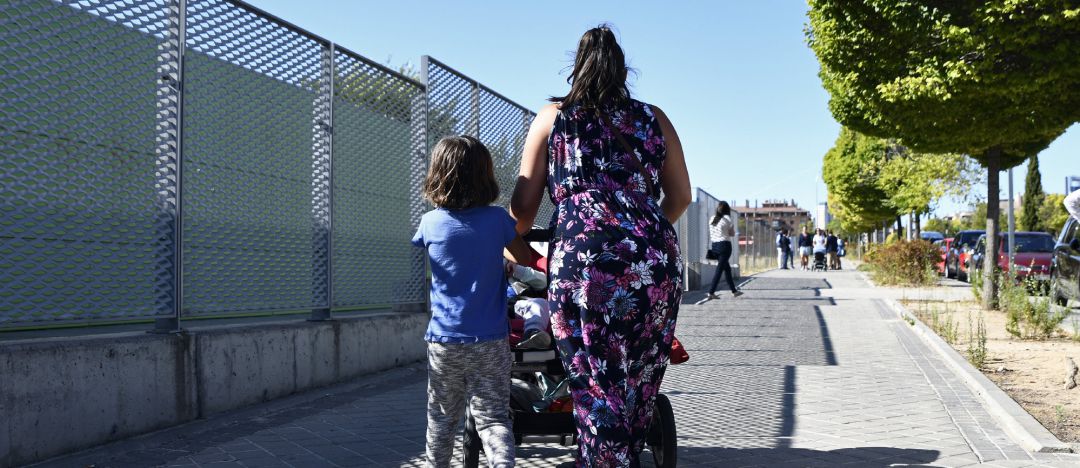 Archivo - Una madre y su hijo empujan el carrito de un bebé en un parque. Archivo - Una madre y su hijo empujan el carrito de un bebé en un parque.
