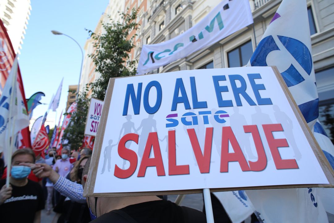 Un trabajador de CaixaBank sostiene una pancarta donde se puede leer "No al ERE salvaje" durante el paro parcial convocado para protestar por el ERE de la entidad financiera, a 7 de junio de 2021, en Madrid Un trabajador de CaixaBank sostiene una pancarta donde se puede leer "No al ERE salvaje" durante el paro parcial convocado para protestar por el ERE de la entidad financiera, a 7 de junio de 2021, en Madrid