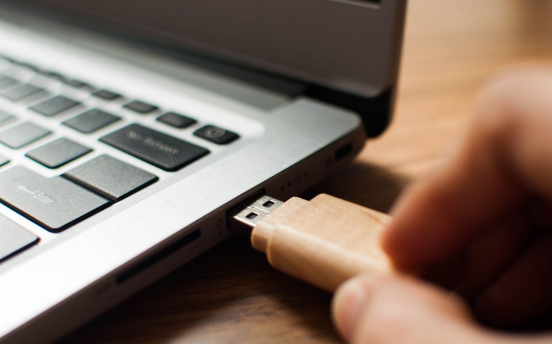 Una persona introduce una memoria USB en un puerto. Una persona introduce una memoria USB en un puerto.