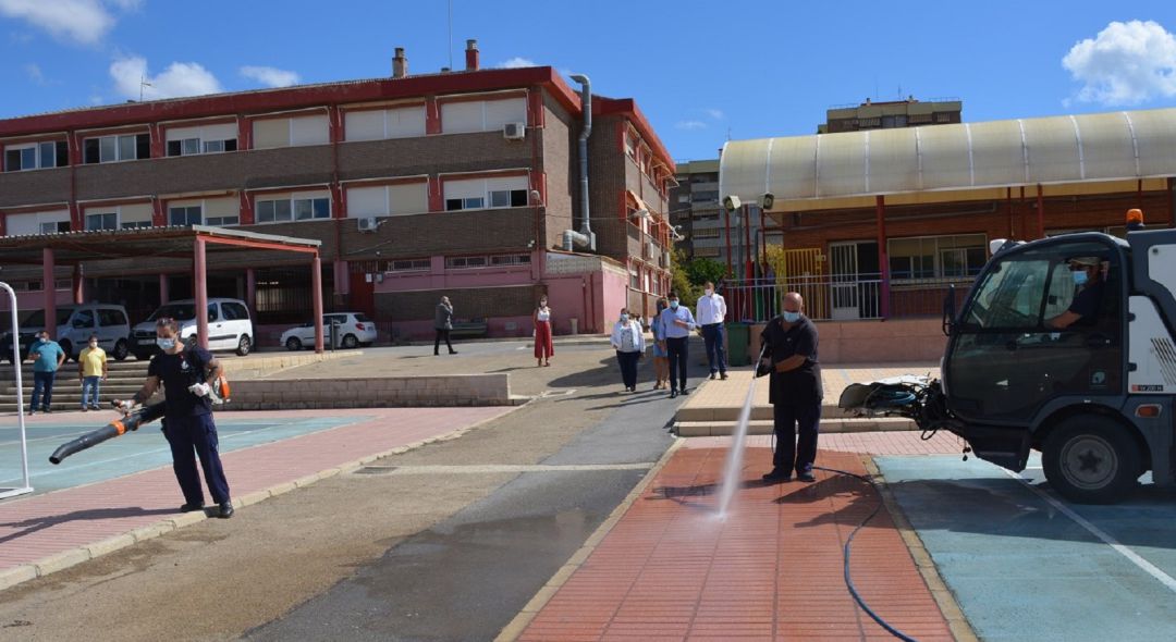 Dos operarios de la anterior contrata de limpieza de colegios desinfectan un patio escolar tras el confinamiento Dos operarios de la anterior contrata de limpieza de colegios desinfectan un patio escolar tras el confinamiento