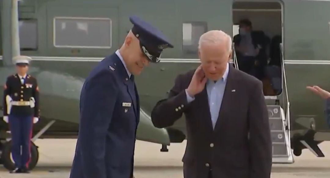 Momento en el que Biden se quita una cigarra del cuello. Momento en el que Biden se quita una cigarra del cuello.