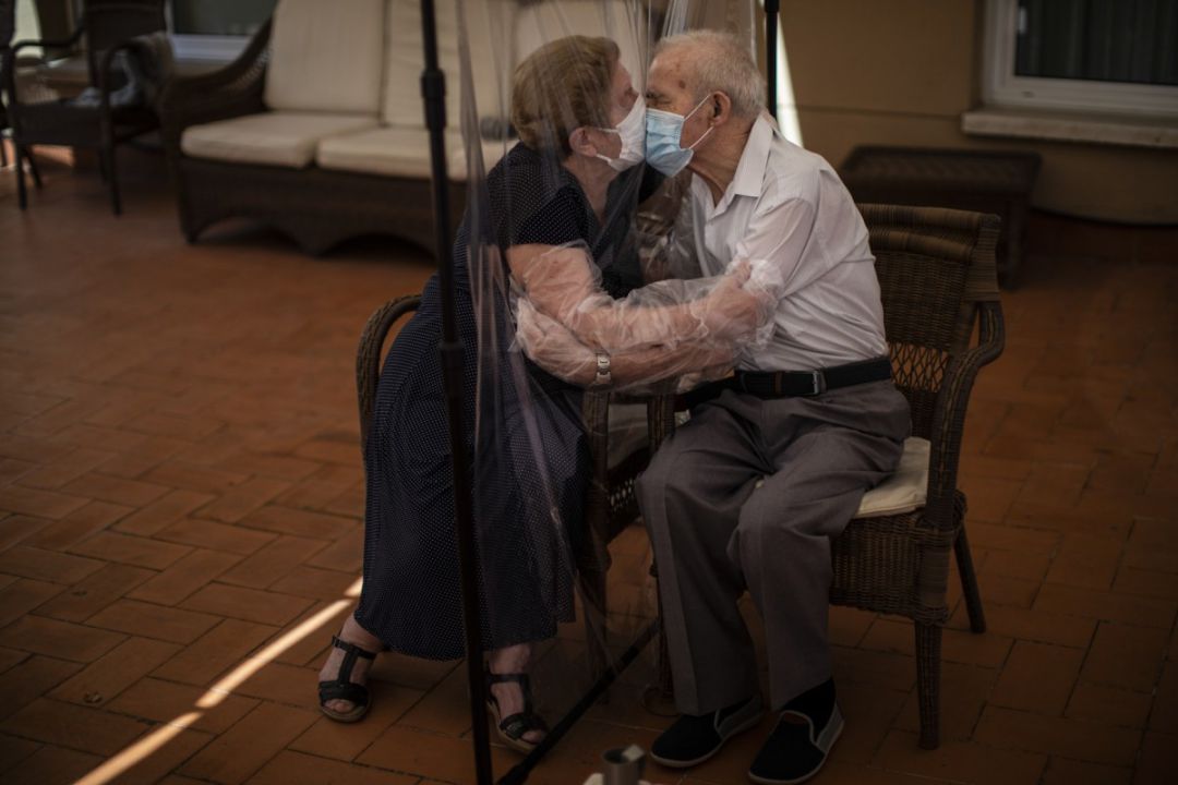 Agustina Canamero (81 años) y Pascual Pérez (84 años) se besan a través de una membrana de plástico para evitar el coronavirus en una residencia de Barcelona el pasado mes de junio de 2020 Agustina Canamero (81 años) y Pascual Pérez (84 años) se besan a través de una membrana de plástico para evitar el coronavirus en una residencia de Barcelona el pasado mes de junio de 2020