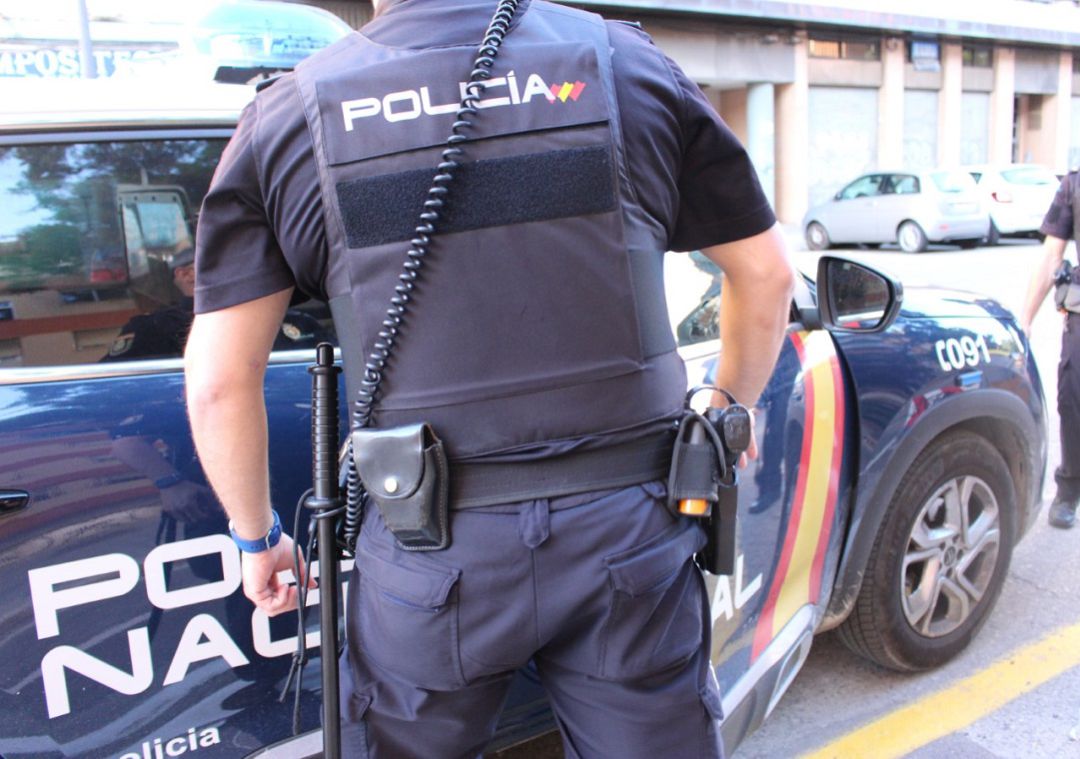Agente de la Policía Nacional junto a un vehículo policial (archivo) Agente de la Policía Nacional junto a un vehículo policial (archivo)