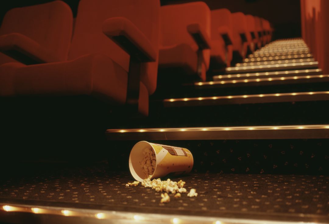 Cubo de palomitas en el suelo tras una sesión de cine Cubo de palomitas en el suelo tras una sesión de cine