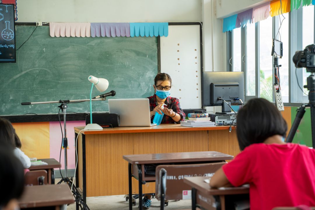 Profesora y alumnos durante una clase en pandemia Profesora y alumnos durante una clase en pandemia