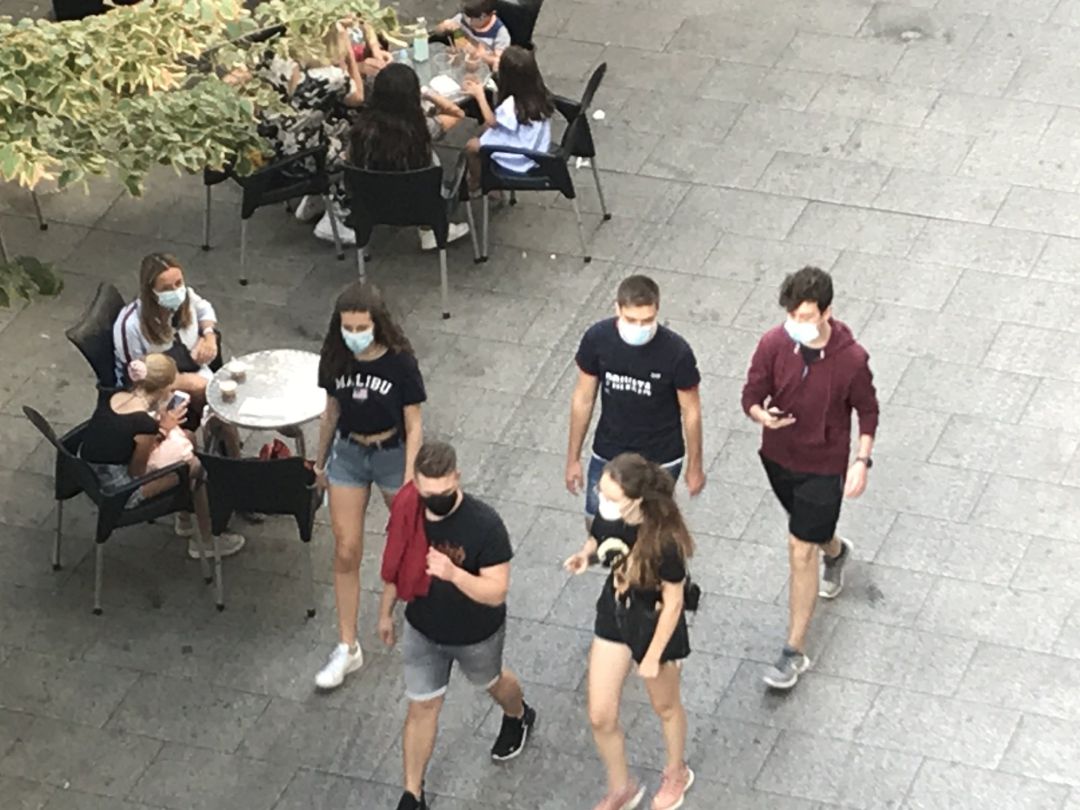 Archivo - Gente paseando con mascarilla delante de una terraza Archivo - Gente paseando con mascarilla delante de una terraza