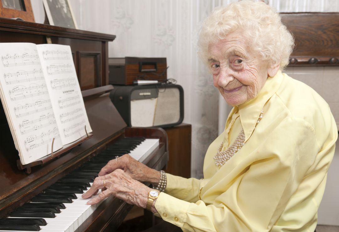 Una mujer de edad avanzada toca el piano. Una mujer de edad avanzada toca el piano.