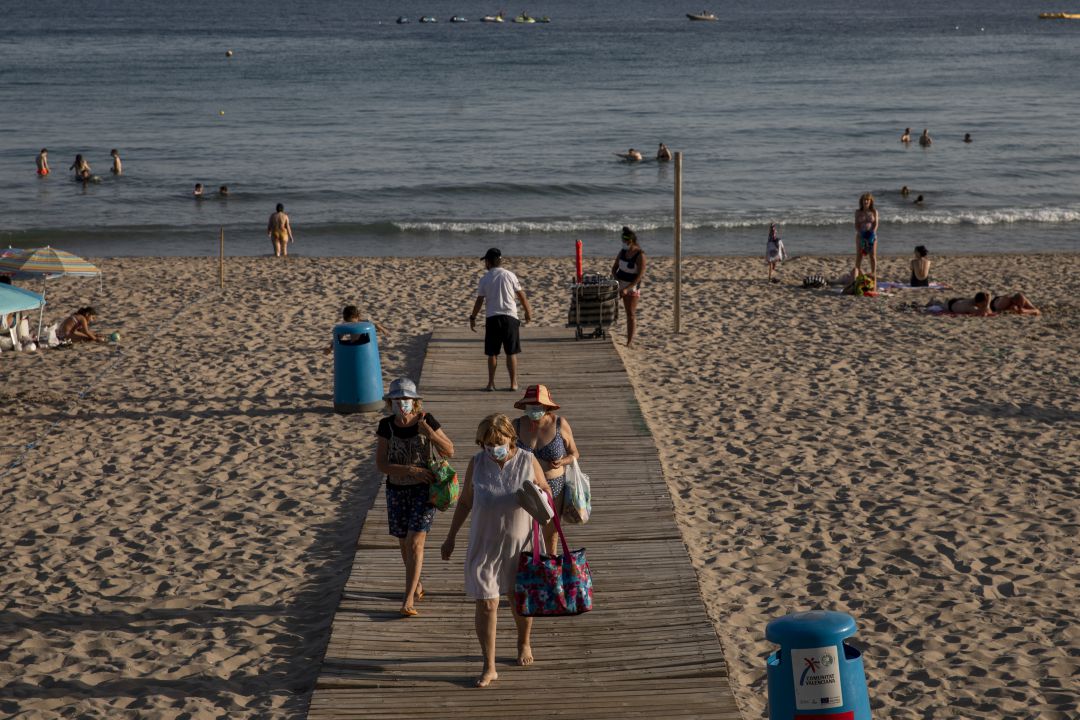 Varias personas salen de una playa de Benidorm, en Alicante. Varias personas salen de una playa de Benidorm, en Alicante.