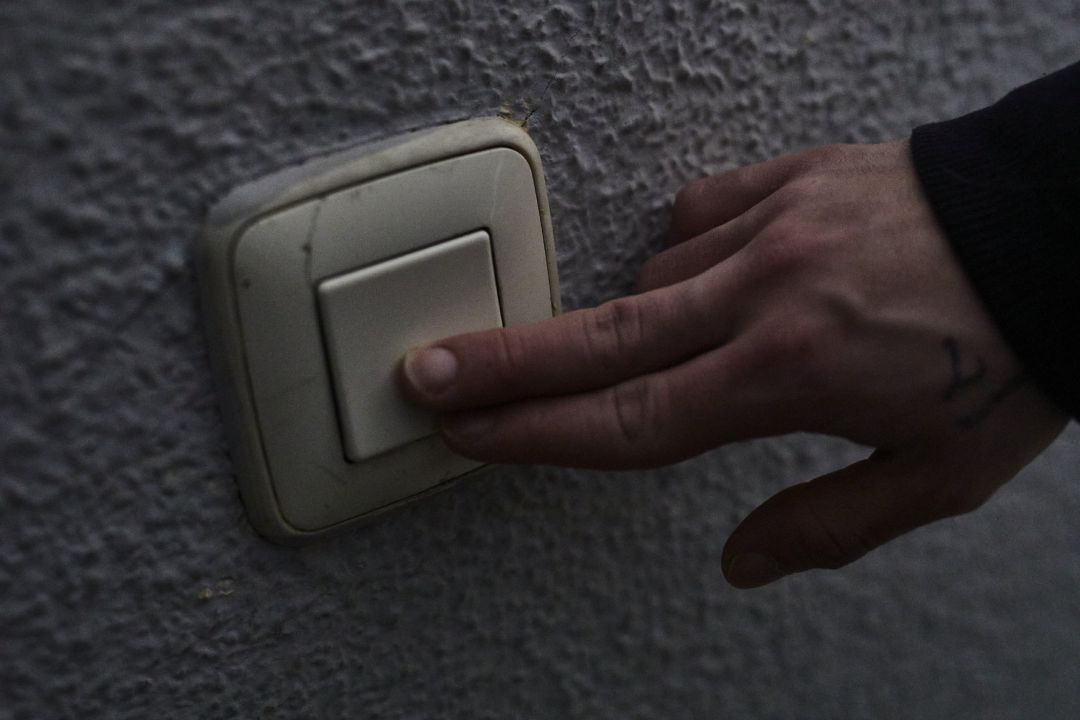 Un hombre toca una llave de la luz Un hombre toca una llave de la luz