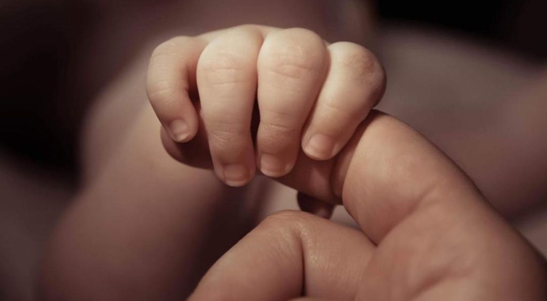 La mano del niño coge un dedo de Marta. La mano del niño coge un dedo de Marta.