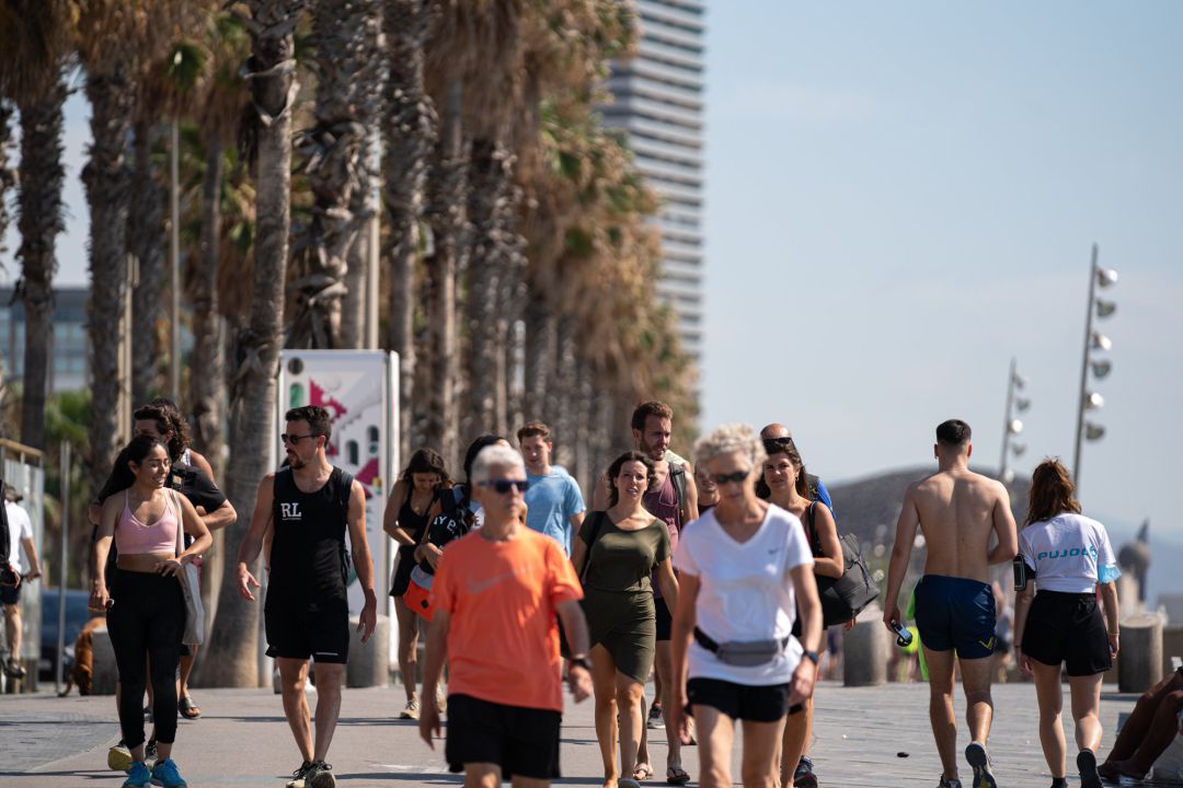 Un grupo de personas pasea por la Barceloneta. Un grupo de personas pasea por la Barceloneta.