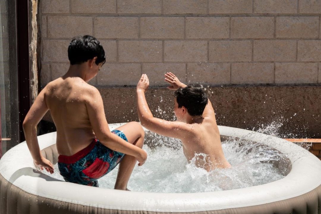 Dos niños juegan en una piscina hinchable Dos niños juegan en una piscina hinchable