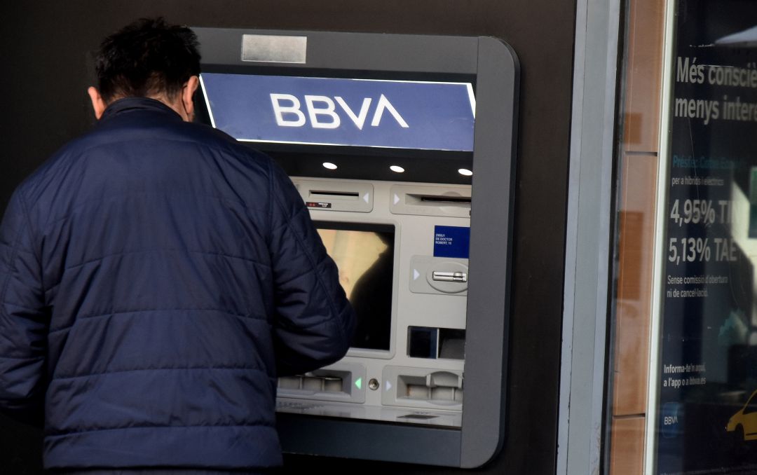 Una persona saca dinero de un cajero. Una persona saca dinero de un cajero.