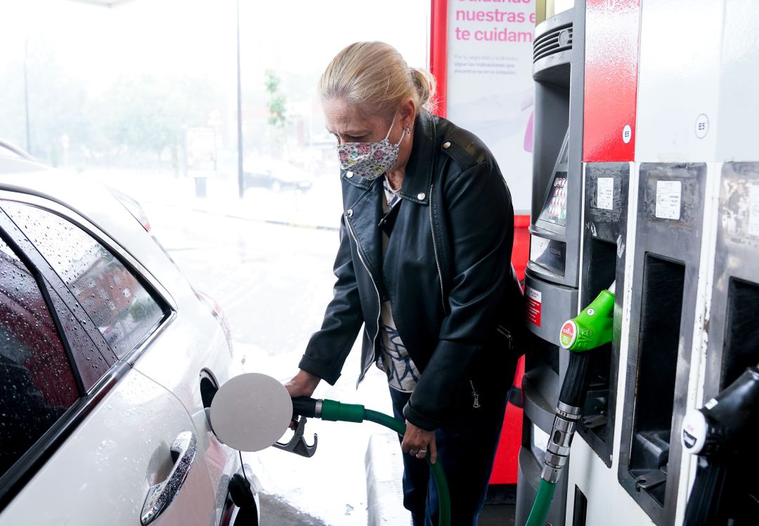 Una mujer echa gasolina a su coche. Una mujer echa gasolina a su coche.