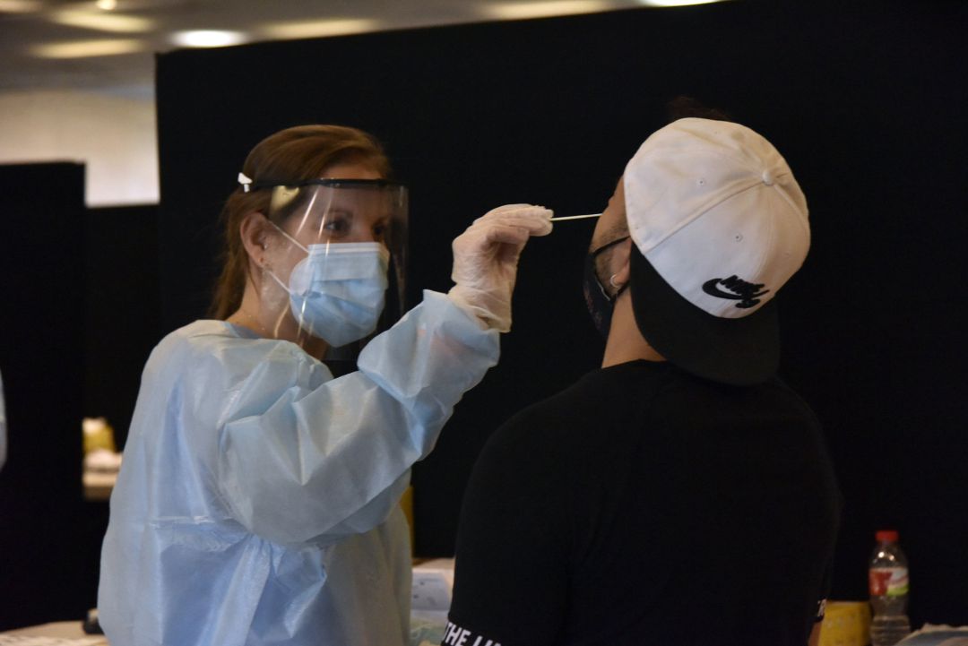 Una trabajadora sanitaria realiza un test de antígenos a un joven Una trabajadora sanitaria realiza un test de antígenos a un joven