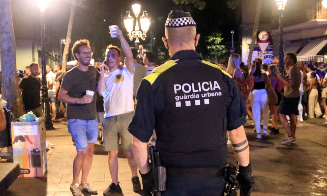 Un agente de la Guardia Urbana de Barcelona desaloja a personas que están realizando un botellón en el paseo del Born Un agente de la Guardia Urbana de Barcelona desaloja a personas que están realizando un botellón en el paseo del Born