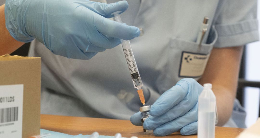 Una sanitaria prepara una vacuna para ser inoculada Una sanitaria prepara una vacuna para ser inoculada