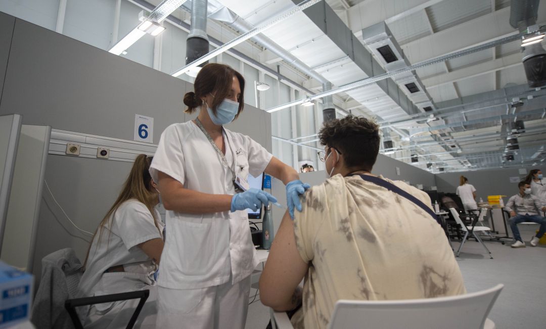 Una enfermera vacunando a un joven en el Hospital Isabel Zendal de Madrid. Una enfermera vacunando a un joven en el Hospital Isabel Zendal de Madrid.