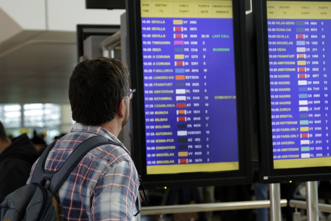 Un pasajero observa los paneles del aeropuerto. Un pasajero observa los paneles del aeropuerto.