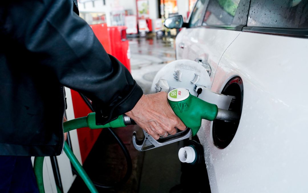 Una mujer pone gasolina a su vehículo en una gasolinera. Una mujer pone gasolina a su vehículo en una gasolinera.