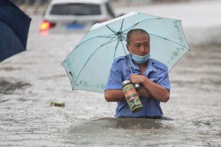 Una persona con un paraguas avanza por la calle con medio cuerpo sumergido en el agua. Una persona con un paraguas avanza por la calle con medio cuerpo sumergido en el agua.