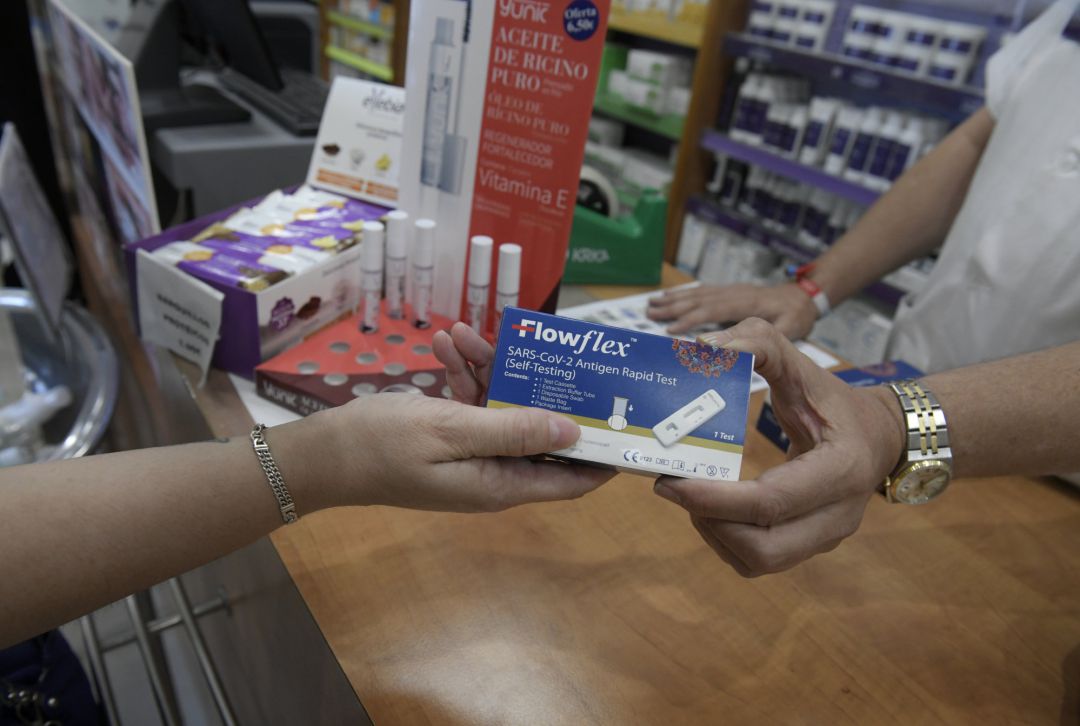 Un farmacéutico enseña un test de antígenos de detección del COVID-19 en una farmacia. Un farmacéutico enseña un test de antígenos de detección del COVID-19 en una farmacia.