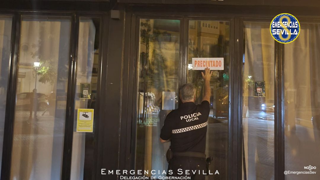 Agente de la Policía Local de Sevilla poniendo el precinto a un local que era reincidente en los incumplimientos Agente de la Policía Local de Sevilla poniendo el precinto a un local que era reincidente en los incumplimientos