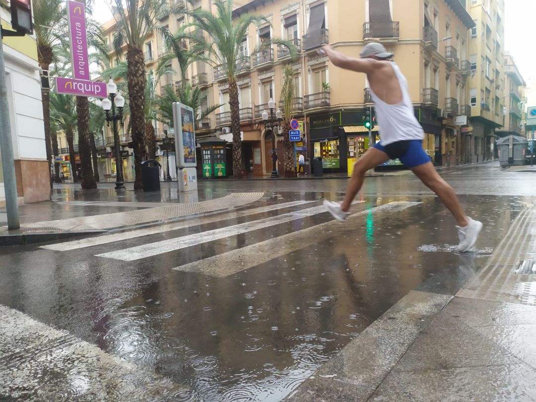 Un viandante intenta sortear un charco tras la lluvia caída a mediodía en la ciudad de Alicante. Un viandante intenta sortear un charco tras la lluvia caída a mediodía en la ciudad de Alicante.