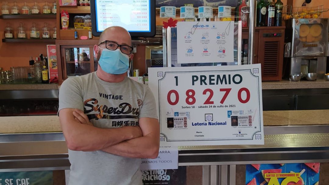 Fran de la Torre, propietario del Bar Mánix posando al lado del número premiado Fran de la Torre, propietario del Bar Mánix posando al lado del número premiado