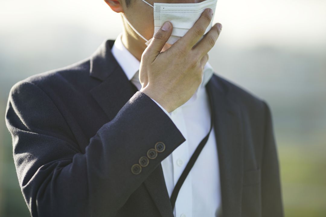 Un hombre se protege del coronavirus con una mascarilla Un hombre se protege del coronavirus con una mascarilla