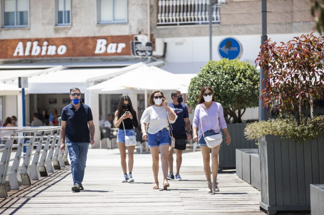Varias personas pasean por Sanxenxo. Varias personas pasean por Sanxenxo.