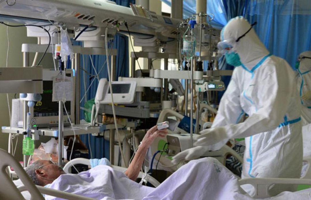 Un sanitario atiende a un paciente infectado por COVID Un sanitario atiende a un paciente infectado por COVID