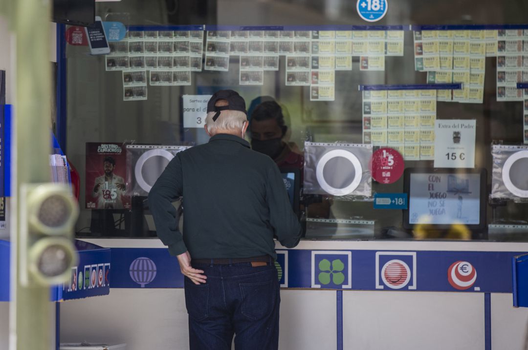 Archivo - Una persona compra lotería en una administración Archivo - Una persona compra lotería en una administración