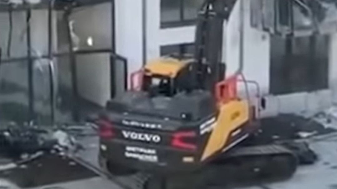 El contratista destruyendo el edificio con una retroexcavadora El contratista destruyendo el edificio con una retroexcavadora