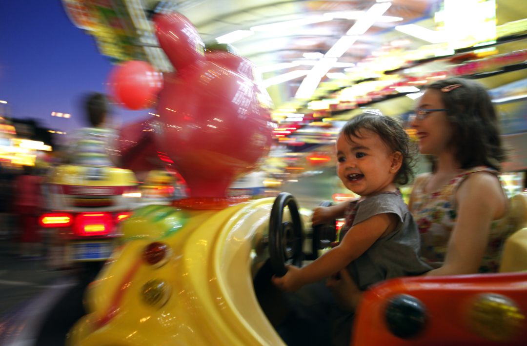 Fotografía de archivo de unas niñas disfrutando de las atracciones infantiles Fotografía de archivo de unas niñas disfrutando de las atracciones infantiles