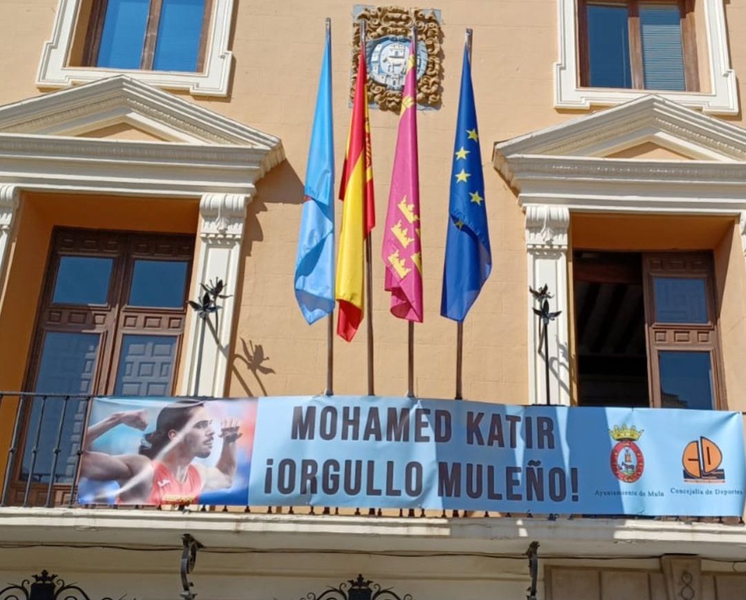 Pancarta en apoyo al atleta español que cuelga desde el balcón del Ayuntamiento de Mula con el lema: 'Mohamed Katir: ¡Orgullo muleño!' Pancarta en apoyo al atleta español que cuelga desde el balcón del Ayuntamiento de Mula con el lema: 'Mohamed Katir: ¡Orgullo muleño!'