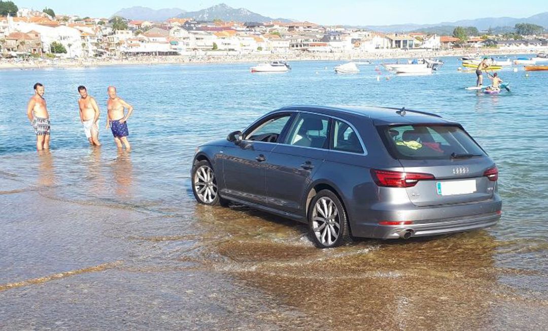 Coche a punto de ser engullido por la marea Coche a punto de ser engullido por la marea