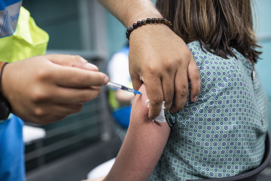 Un sanitario administra una dosis de la vacuna de Pfizer a una mujer en el Wizink Center. Un sanitario administra una dosis de la vacuna de Pfizer a una mujer en el Wizink Center.