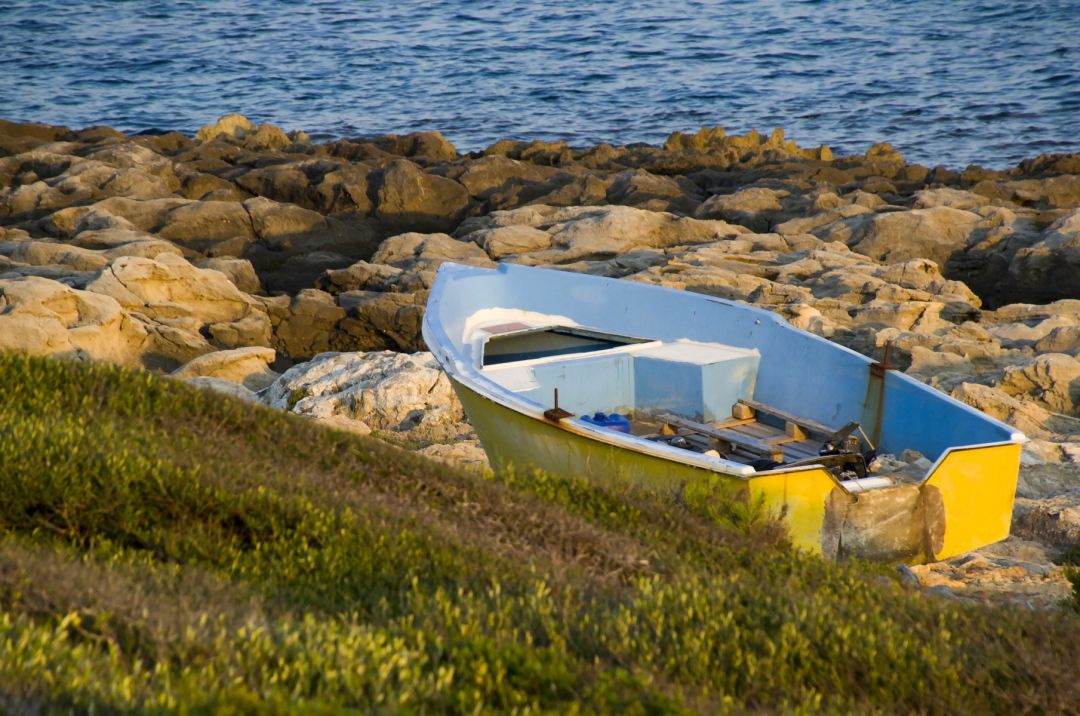 Imagen de archivo de una patera abandonada en la costa Imagen de archivo de una patera abandonada en la costa