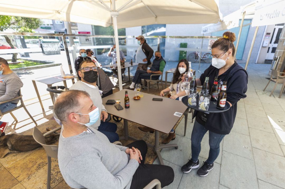 Clientes en una terraza son atendidos por una camarera. Clientes en una terraza son atendidos por una camarera.