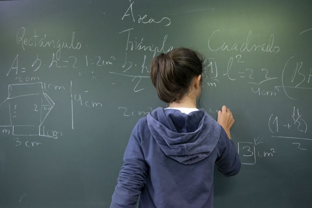 Imagen de archivo de una alumna en una pizarra Imagen de archivo de una alumna en una pizarra