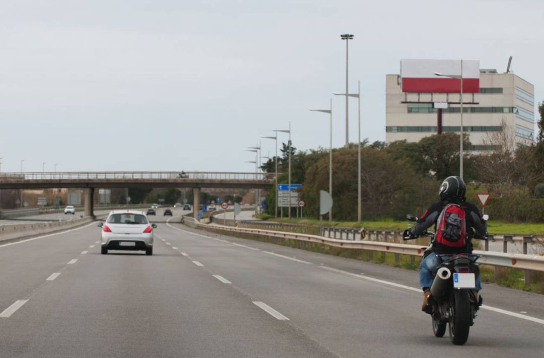 Una moto circulando por una carretera Una moto circulando por una carretera
