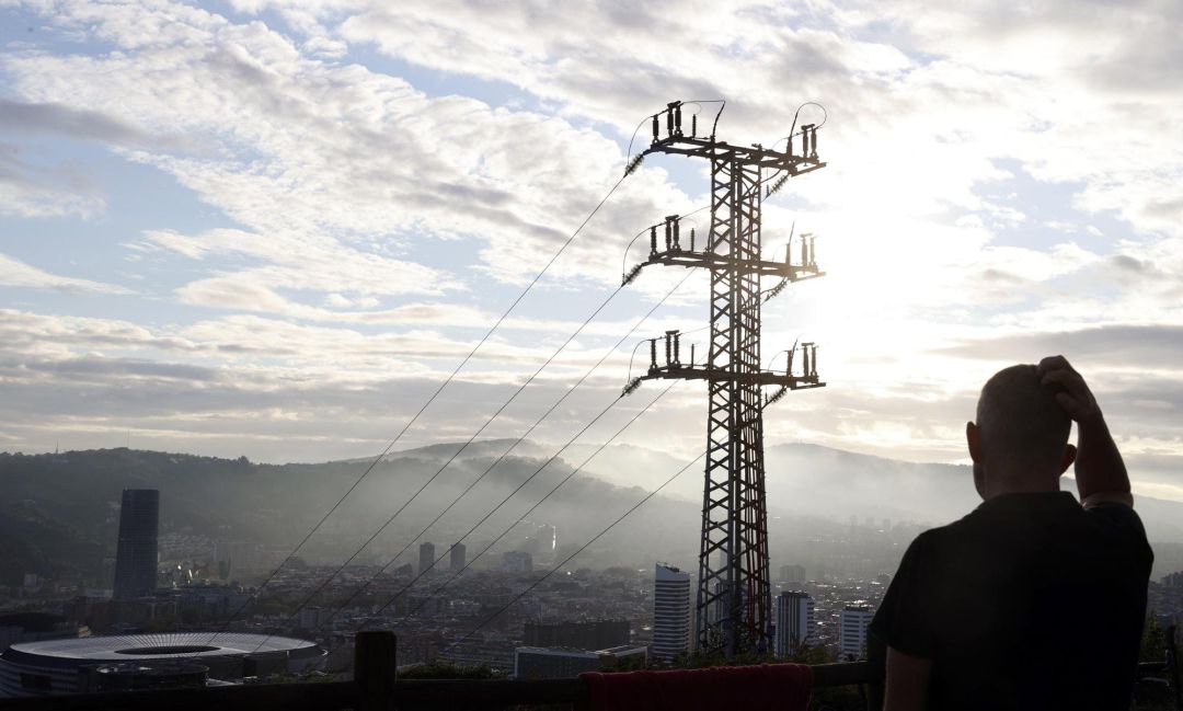 Una persona observa el cableado con el que red eléctrica transporta la energía sobre la ciudad de Bilbao. Una persona observa el cableado con el que red eléctrica transporta la energía sobre la ciudad de Bilbao.